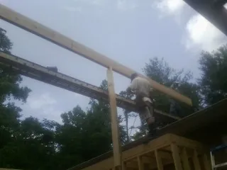 Carpenter setting a ridge beam over a new addition frame — Ice Dam Removal by Roofing Brothers in Mountainside