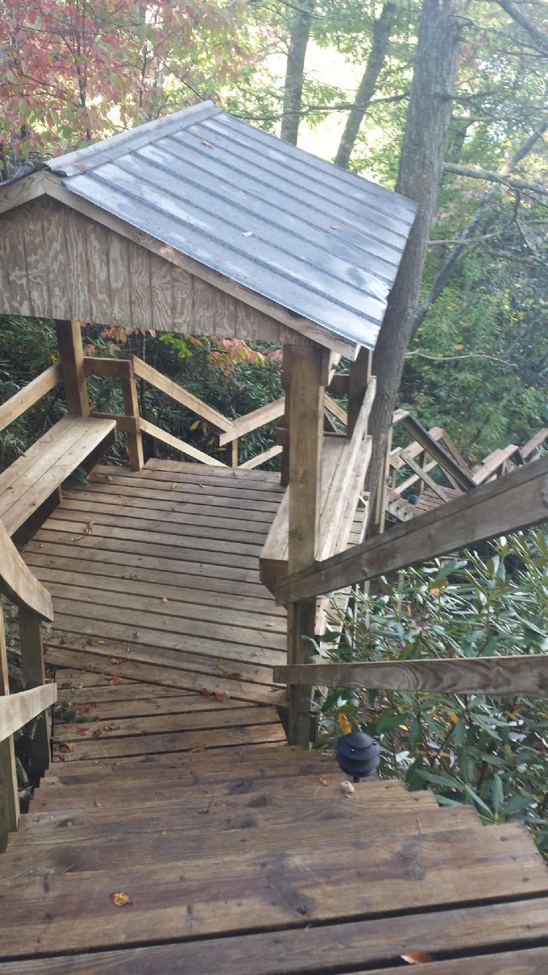 Metal roofed shelter over wooden steps on a wooded walkway — Skylight Repair & Installation work by our crew in Mountainside