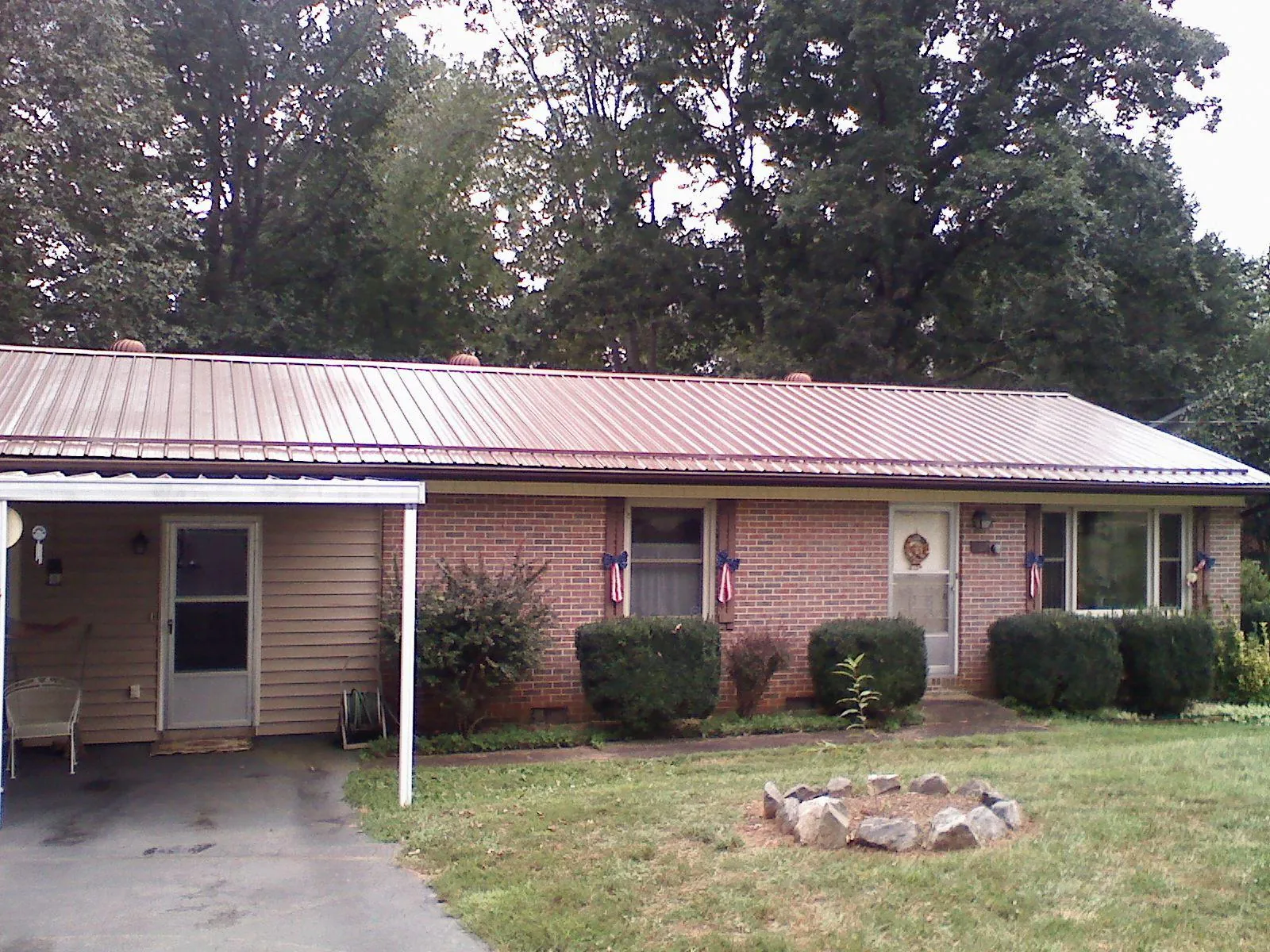 Bronze metal roof and carport on a brick ranch home — Roof Repair work by our crew in Mountainside