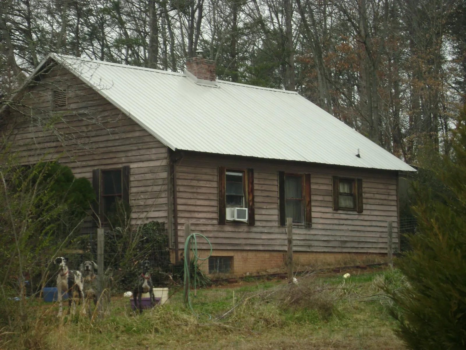 White metal roof on an old wood sided farmhouse, from a Metal Roof Installation job in Mountainside